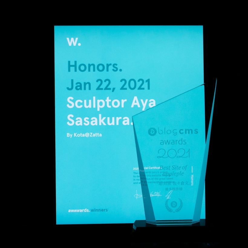 アップルップル賞のトロフィーとAwwwwardsのHonorable Mention受賞証明書。